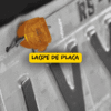Imagem em preto e branco com destaque colorido em um lacre de placa laranja fixado na parte superior da placa veicular metálica, com foco informativo.