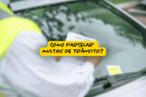Agente de trânsito colocando multa no para-brisa de um carro, com sobreposição de texto perguntando como parcelar multas de trânsito.