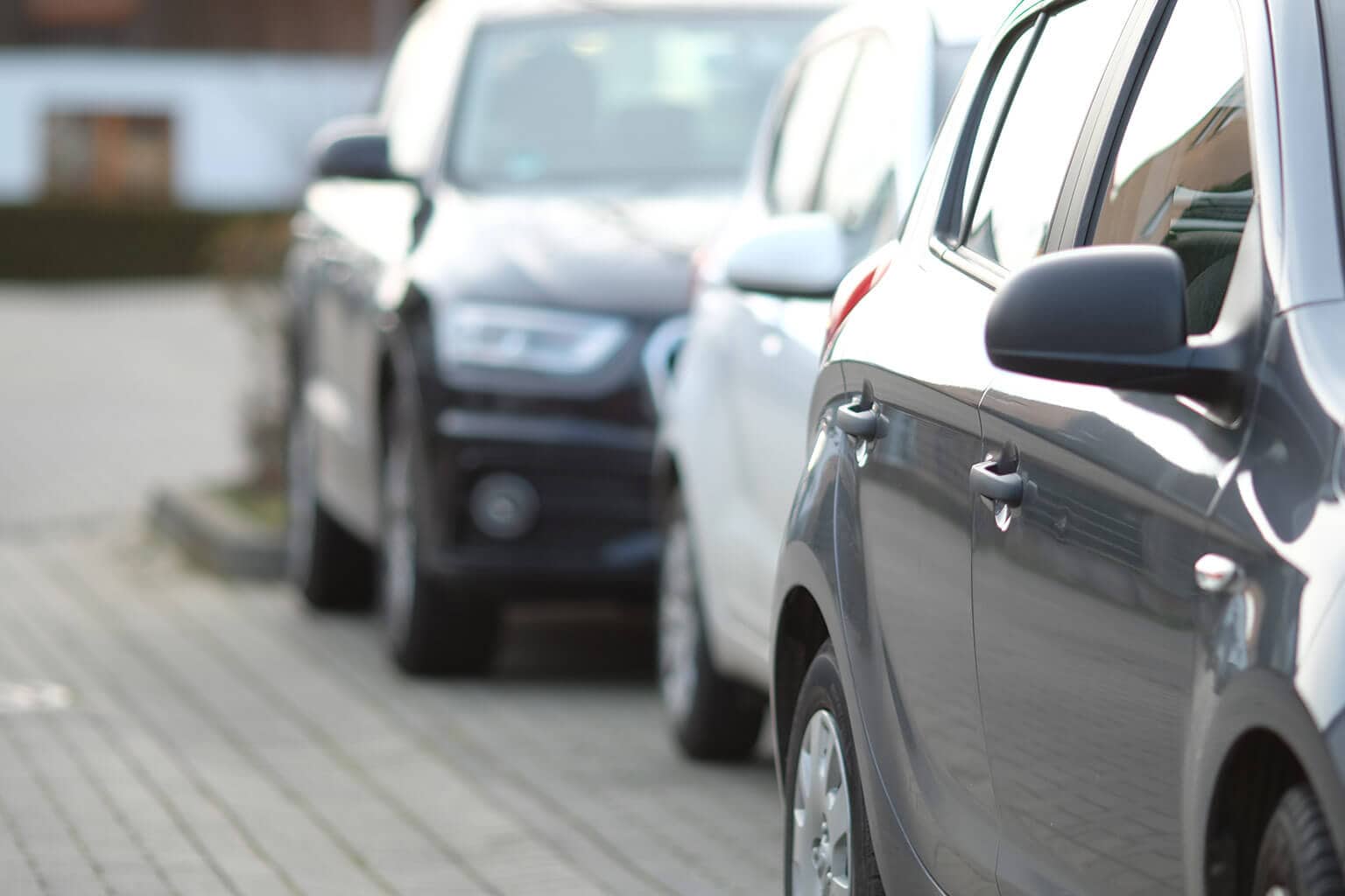 três carros estacionados correndo o risco de levar uma multa de zona azul