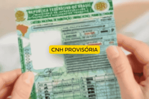 Pessoa segurando uma carteira nacional de habilitação brasileira em tom esverdeado, representando uma CNH provisória. No centro da imagem há um selo amarelo com a inscrição “CNH provisória”, destacando o documento temporário para novos condutores.
