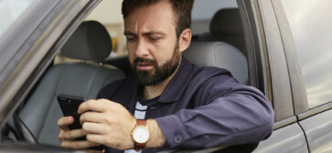 veiculo bloqueado para licenciamento - motorista com carro parado e celular na mão vendo bloqueio do carro