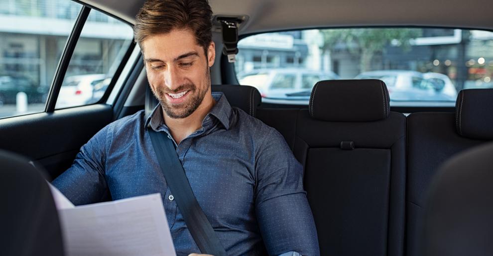 Homeme em banco de carro vendo documentos