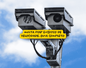 Duas câmeras de monitoramento de trânsito instaladas em um poste contra um céu azul com nuvens, com destaque para a frase “Multa por excesso de velocidade: guia completo” em faixa amarela.