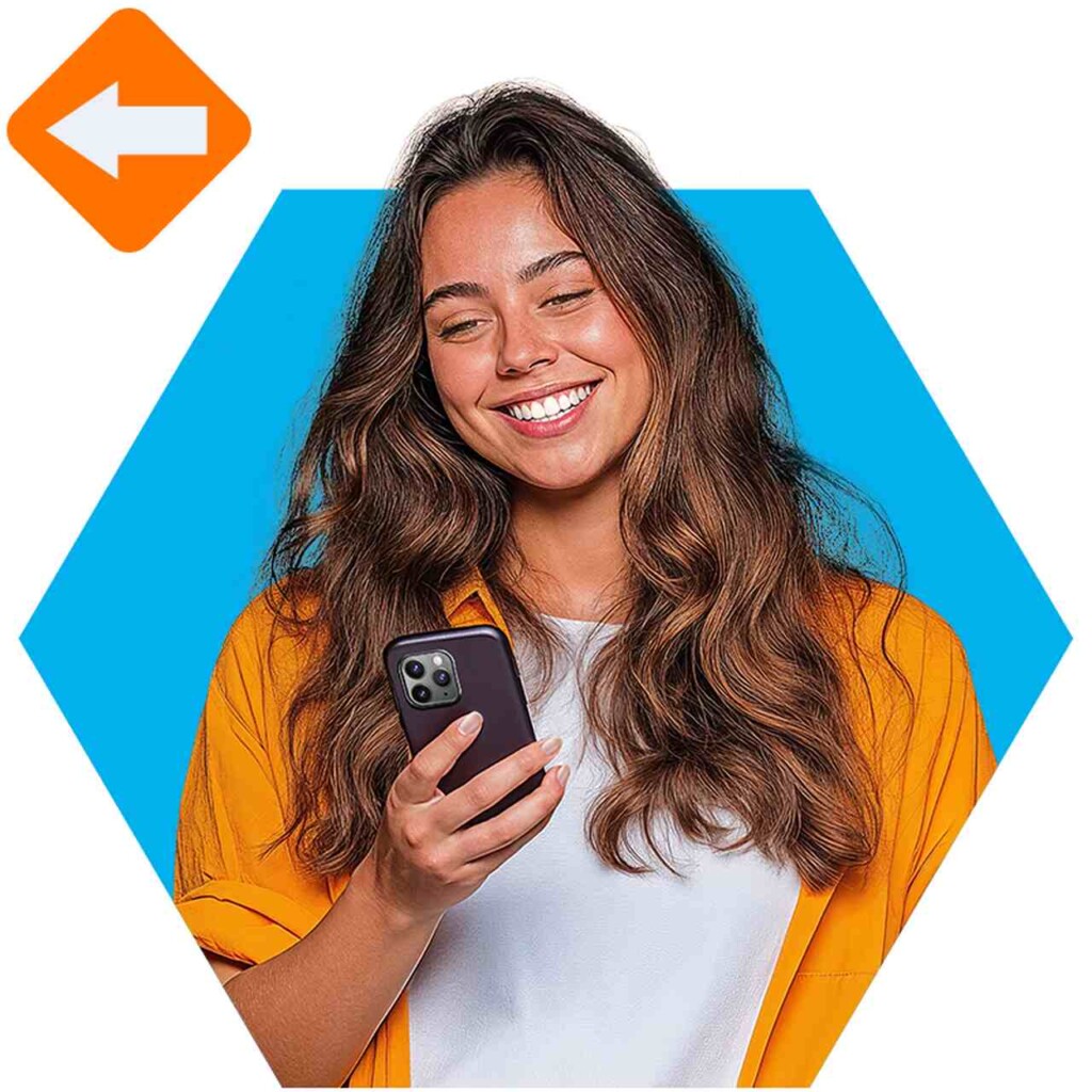 Imagem de uma mulher lendo sobre o que é licenciamento na tela do celular. Ela usa uma camisa laranja e está com expressão feliz.