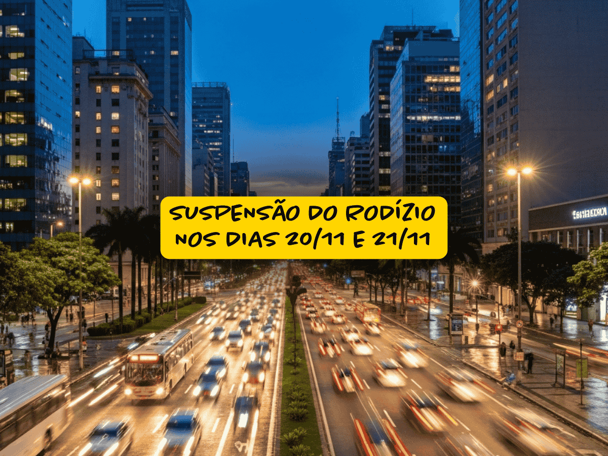 Avenida movimentada com fluxo intenso de carros e ônibus ao entardecer na cidade de São Paulo, com destaque para o aviso em destaque amarelo informando sobre a suspensão do rodízio nos dias 20/11 e 21/11.