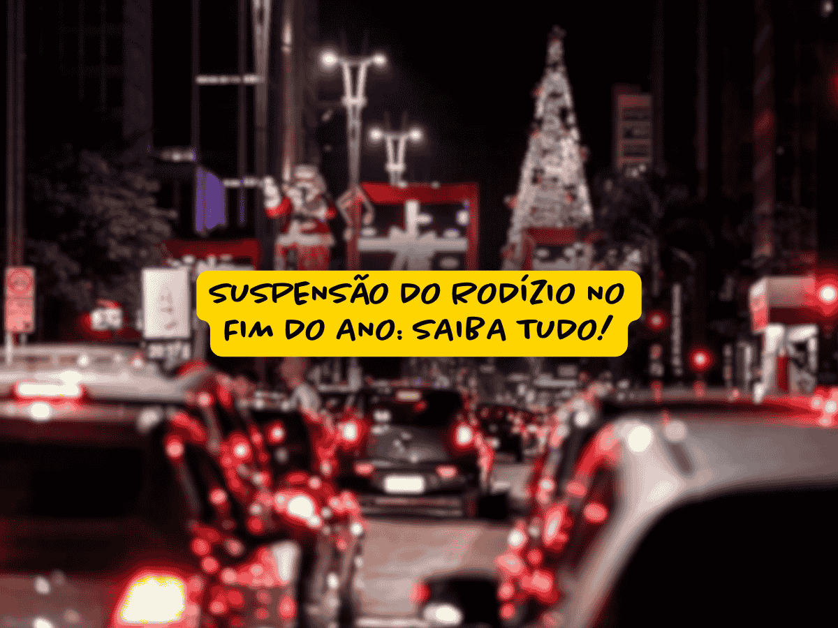 Trânsito intenso à noite na Avenida Paulista com decoração natalina e árvore de Natal iluminada ao fundo, destacando aviso sobre suspensão do rodízio no fim do ano em faixa amarela central.