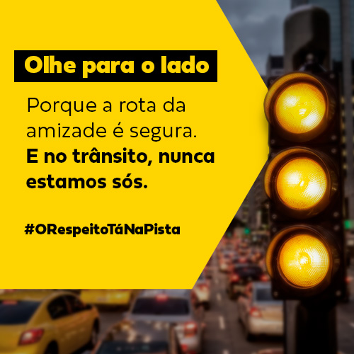 Semáforo amarelo aceso em avenida urbana movimentada com mensagem educativa sobre segurança no trânsito e respeito entre motoristas, destacando a campanha “Olhe para o lado” e a importância da amizade no trânsito seguro (banner sidebar)