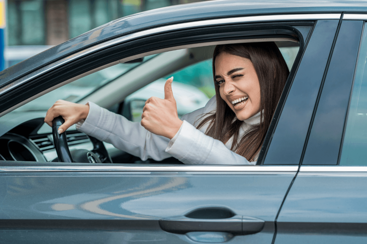 Motorista feliz fazendo sinal de positivo dentro do carro após concluir o processo de Renovar CNH RJ.