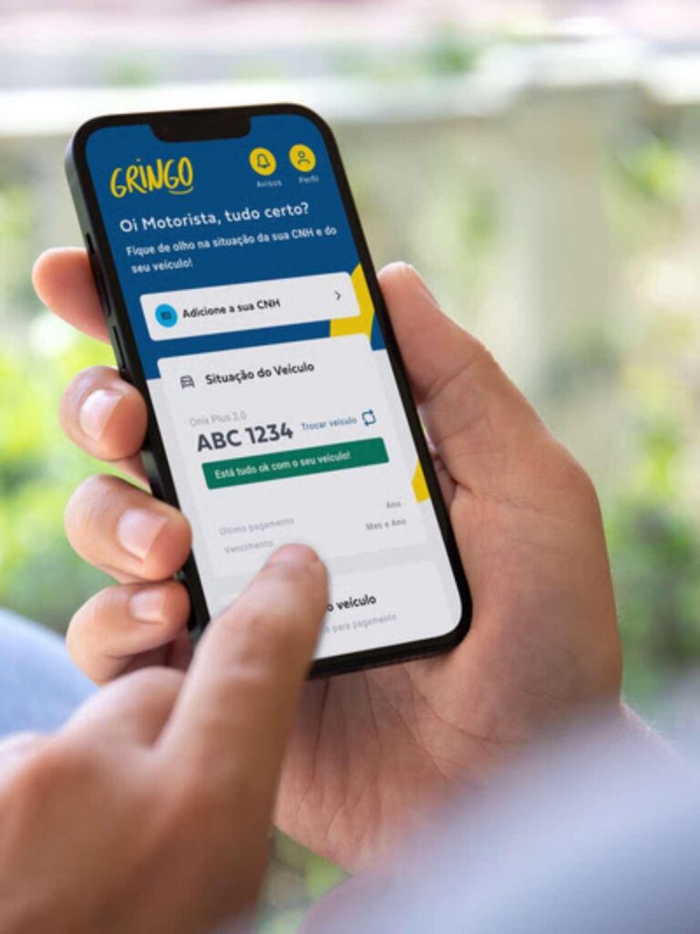 Pessoa utiliza o aplicativo Gringo no celular para consultar e pagar o IPVA do veículo.