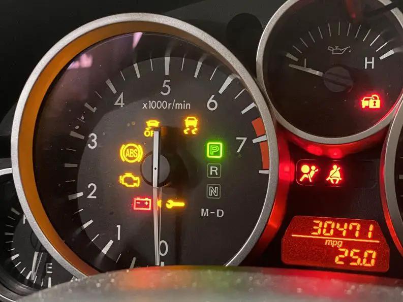 Painel do carro com várias luzes de advertência acesas, indicando possível falha elétrica ou problema na alimentação do veículo.